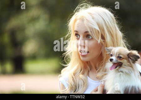 Woman holding fluffy chien dans le parc Banque D'Images