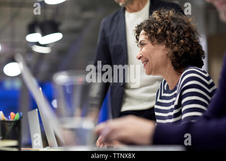 Senior businesswoman Smiling at conference table avec des collègues en réunion Banque D'Images