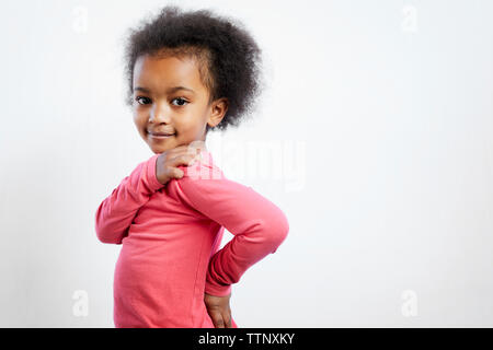 Portrait of smiling Girl standing against white background Banque D'Images