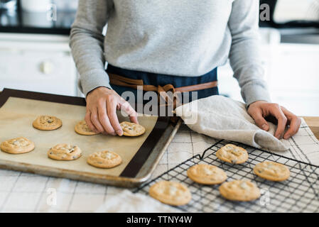 Portrait femme organiser les cookies sur une grille dans la cuisine Banque D'Images