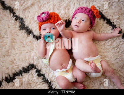 Vue aérienne de baby girls lying on rug Banque D'Images