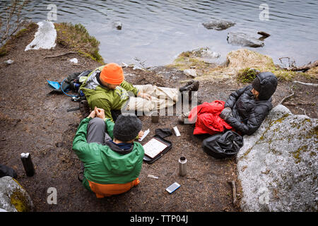 High angle view amis jouant au Scrabble en position assise au Lakeshore Banque D'Images