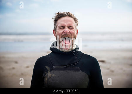 Homme debout à crier surfer beach Banque D'Images