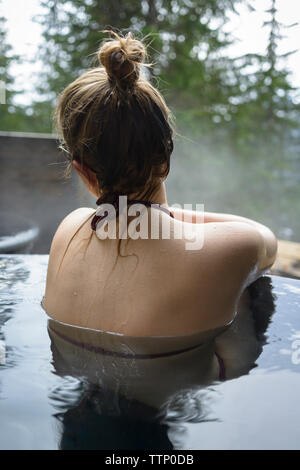 Rear view of woman relaxing in Hot spring Banque D'Images