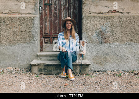 Portrait de femme avec Jack Russell Terrier assis sur avant stoop Banque D'Images