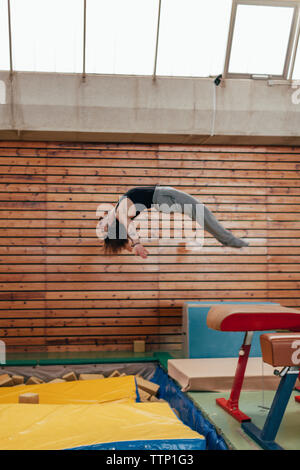 Vue latérale d'un saut d'équipement de gymnastique gymnaste at gym Banque D'Images