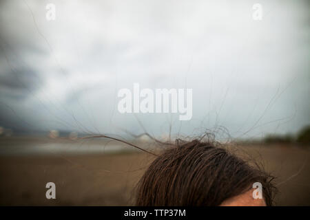 Portrait de femme à Spanish Banks Beach Park contre ciel nuageux Banque D'Images