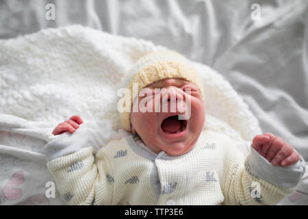 Vue aérienne de girl crying while lying on bed at home Banque D'Images