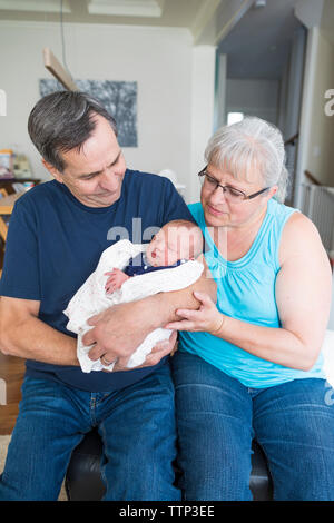 Les grands-parents avec mignon petite-fille nouveau-né à la maison Banque D'Images