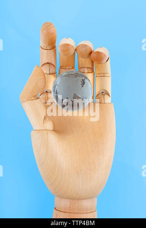 Wooden Hand holding globe de verre sur fond blanc Banque D'Images
