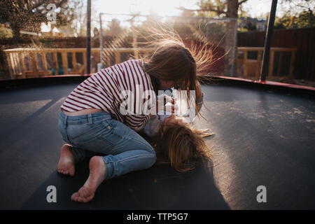 Portrait de sœurs jouant sur trampoline Banque D'Images