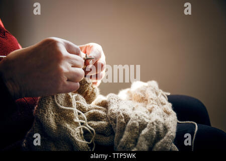 Portrait of senior woman knitting at home Banque D'Images