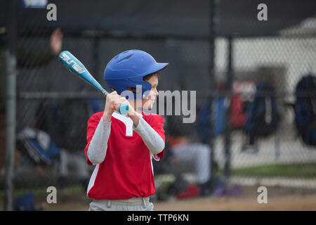 Garçon jouant au baseball au terrain de sport Banque D'Images