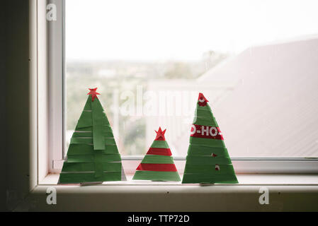 Gros plan des arbres de noël en papier sur le rebord de la fenêtre à la maison Banque D'Images