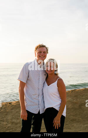 Portrait of happy mother with son comité permanent sur la falaise contre la mer au coucher du soleil Banque D'Images