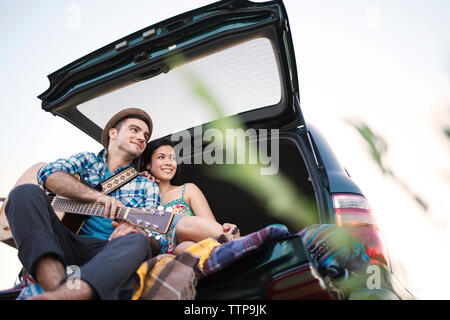 Low angle view of happy couple sitting in car Banque D'Images