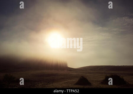 Soleil qui brille plus de paysage pendant temps de brouillard Banque D'Images