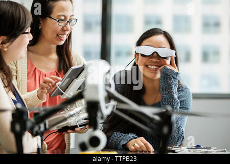 Étudiante portant des lunettes de réalité virtuelle tout en enseignant à l'aide de l'ordinateur tablette dans la salle de classe Banque D'Images