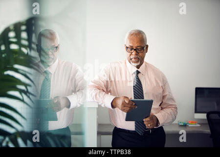 Médecin à l'aide de l'ordinateur tablette en position debout dans le hall de l'hôpital Banque D'Images