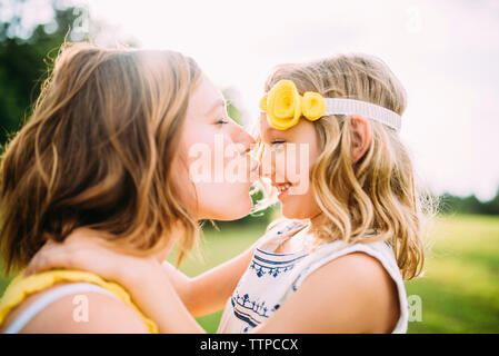 Femme fille baiser sur le nez du park Banque D'Images