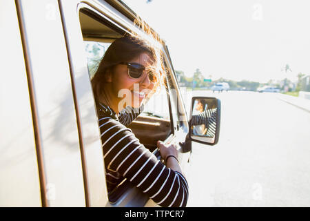 Portrait de femme heureuse dans un mini-van sur route Banque D'Images