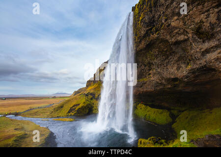 Vue panoramique de cascade contre ciel nuageux Banque D'Images