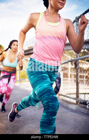 Portrait de femme sportive jogging avec des amis sur street Banque D'Images