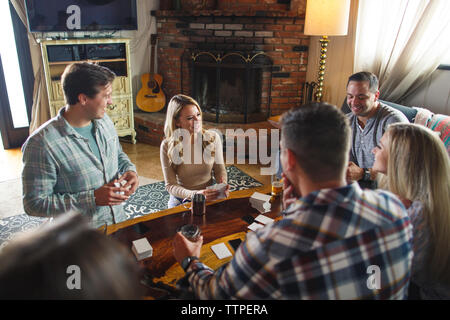 Happy friends enjoying card game au cours de rassemblement social à la maison Banque D'Images