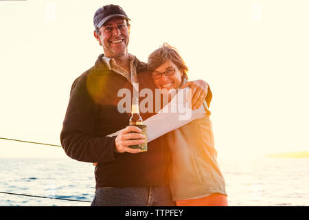 Portrait of smiling woman en se tenant sur le bateau contre un ciel clair Banque D'Images