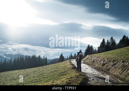 Man and Woman standing on mountain contre ciel nuageux Banque D'Images