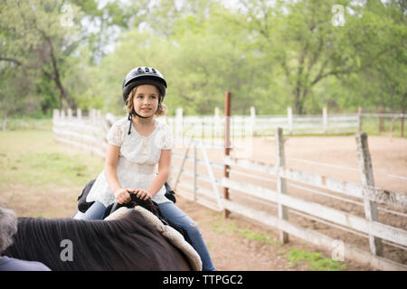 Fille à la voiture tandis que l'équitation au Ranch Banque D'Images