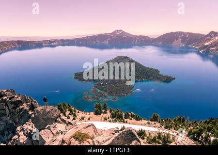 Woman looking at view en se tenant sur le rock against clear sky Banque D'Images