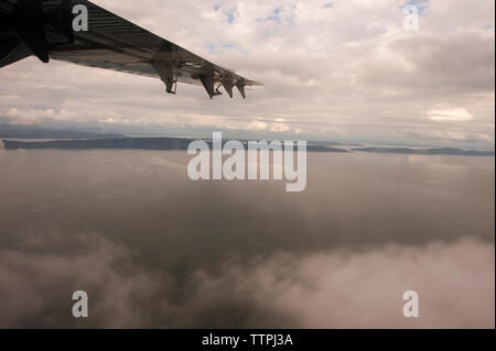 Image recadrée de vol d'un avion sur seascape Banque D'Images