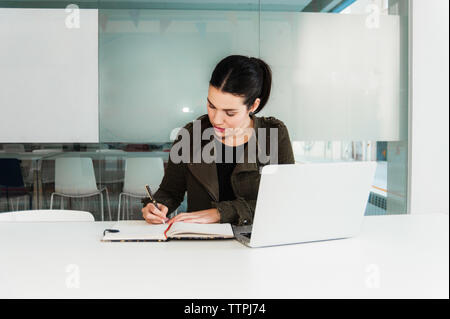 Young Hispanic Woman working on Laptop in Classroom Banque D'Images