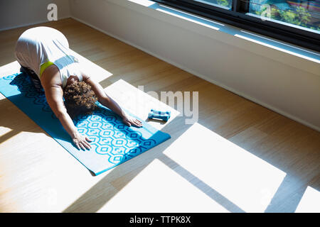 High angle view of woman practicing yoga on exercise mat in studio Banque D'Images