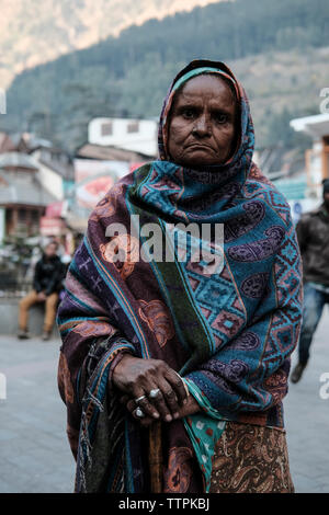 Portrait of serious mature woman with blanket standing en ville Banque D'Images