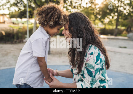 Vue latérale d'happy mother and son toucher front at park Banque D'Images