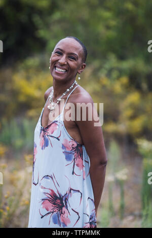 Portrait of happy woman standing contre des plantes dans le parc Banque D'Images