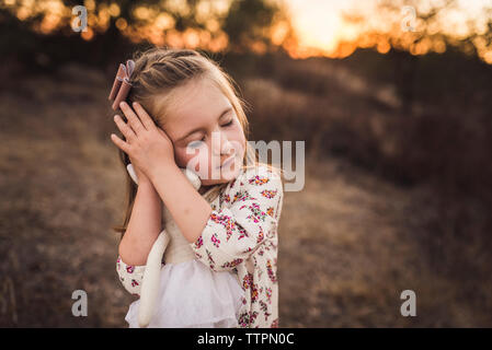 Portrait of young girl holding animal en peluche jouet avec les yeux fermés Banque D'Images