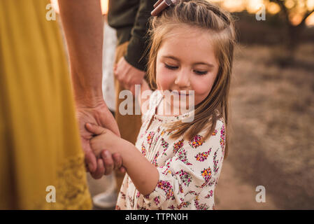 Young Girl holding parents mains regardant vers le bas dans le champ de la Californie Banque D'Images