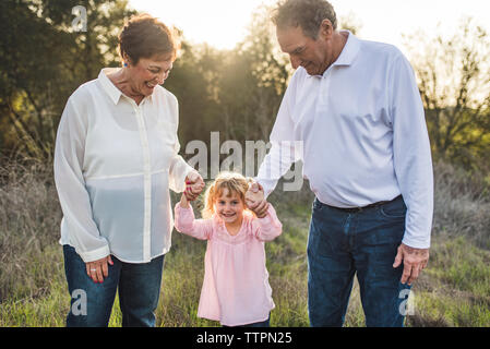 Portrait de grands-parents holding little girls part dans le champ Banque D'Images