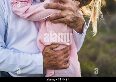 Close up de grands-pères bras enroulés autour de jeune petite-fille Banque D'Images