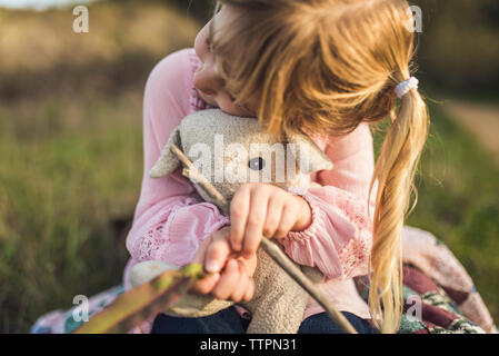 Jeune fille blonde tenant son animal en peluche et de câlins