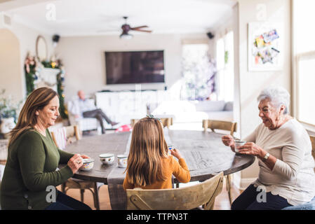 Famille de plusieurs générations de jouer avec un plateau de table de cuisine Banque D'Images