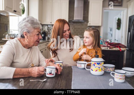 Famille de plusieurs générations de jouer avec un plateau de table de cuisine Banque D'Images