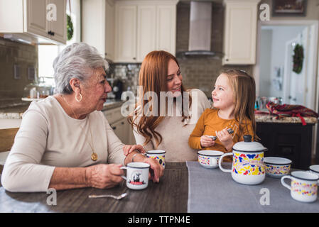 Famille de plusieurs générations de jouer avec un plateau de table de cuisine Banque D'Images