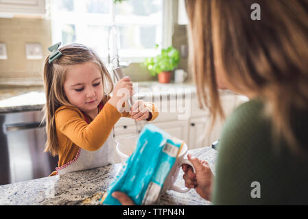 Grand-mère et petite-fille, ce qui fait du petit déjeuner de crêpes dans la cuisine Banque D'Images