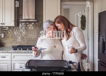 Senior woman et petite-fille adultes la cuisson des crêpes pour le petit déjeuner Banque D'Images