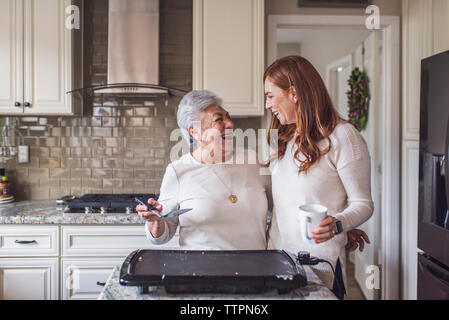 Senior woman et petite-fille adultes la cuisson des crêpes pour le petit déjeuner Banque D'Images