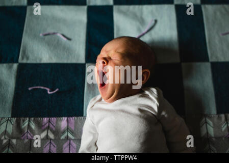 Portrait of cute baby girl de bâiller pendant le sommeil on bed Banque D'Images